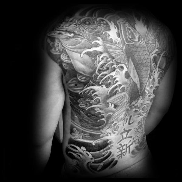 Black and grey Japanese-style full-back tattoo featuring a large frog, koi fish, and powerful waves, with bold kanji characters symbolizing transformation.