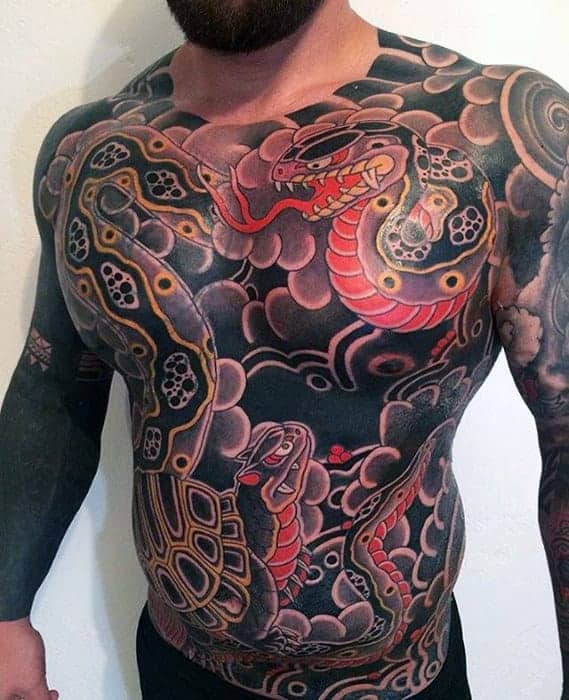 Japanese full-chest tattoo featuring coiled snakes, bold black and red patterns, intricate scales, and dynamic cloud designs