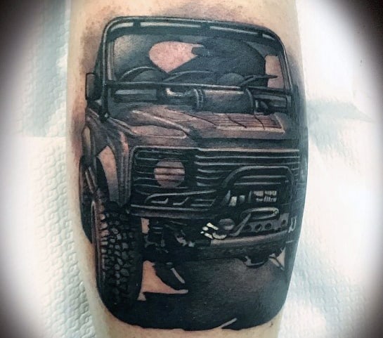 Bold black and grey tattoo of an off-road Jeep with intricate shading, showcasing a rugged front view and powerful stance for an adventurous look.