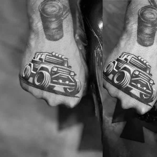 Bold black ink tattoos of matching off-road Jeep designs on both hands, featuring thick lines and a rugged, cartoonish style.