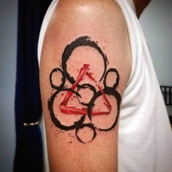 Coheed and Cambria Keywork tattoo on the upper arm with bold black rings and a striking red triangle, blending power and contrast.
