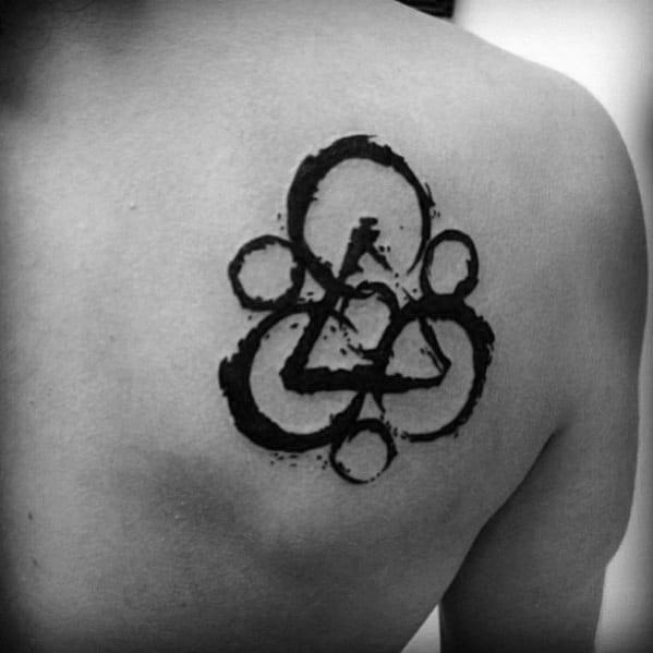 Black Keywork tattoo on the shoulder blade with brushstroke texture, representing Coheed and Cambria’s iconic symbol in a bold, artistic style.