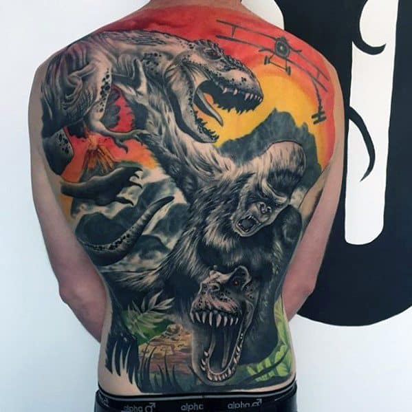 Epic full-back King Kong tattoo in color, showing Kong battling a T-Rex with a fiery sunset, mountains, and vintage plane in the background.