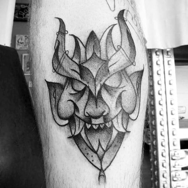 Geometric black and grey Krampus tattoo with a stylized horned face, closed eyes, sharp teeth, and dotted shading for texture.