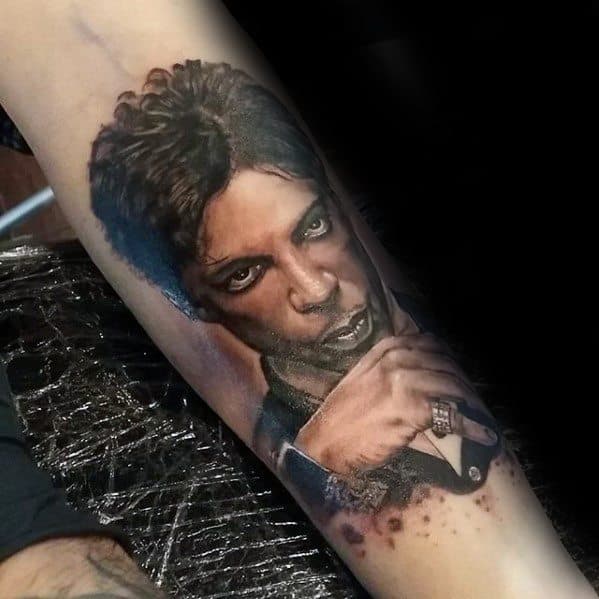 Tattoo of Prince with curly hair and an intense gaze on a forearm