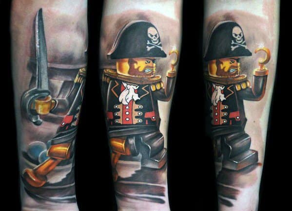 Vibrant full forearm tattoo of a Lego pirate minifigure with a hook hand, peg leg, and sword, featuring rich colors and dynamic shading.