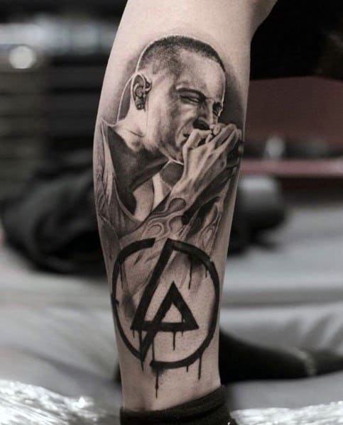 Black and gray tattoo of Chester Bennington singing, featuring realistic shading and a dripping Linkin Park logo on the leg.