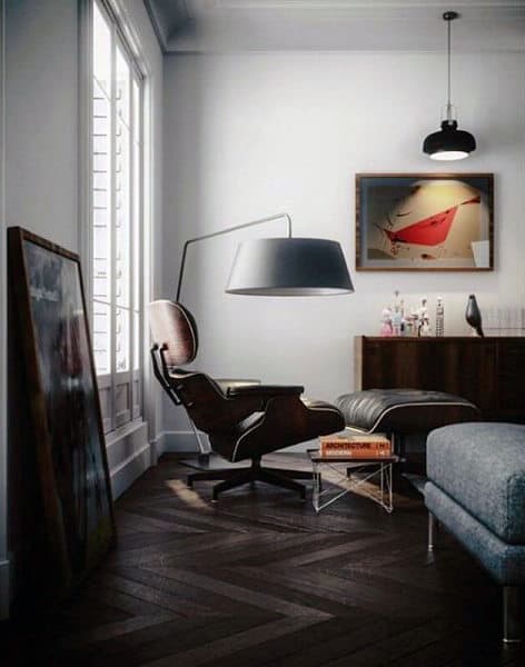 Artistic living room design with modern lounge chair, floor lamp, and dark wood flooring.