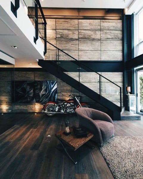 Industrial loft with modern staircase, textured walls, and motorcycle as decor centerpiece.