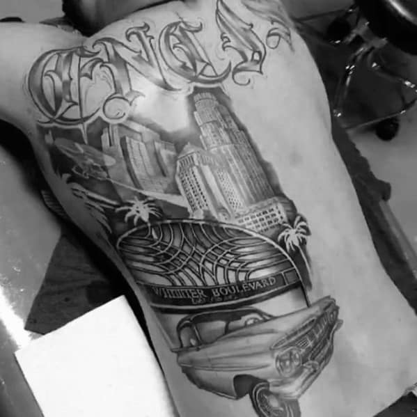 Full side torso tattoo featuring Los Angeles skyline, Whittier Boulevard sign, classic lowrider car, palm trees, and bold script.