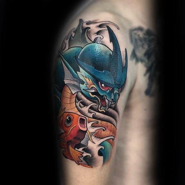 Magikarp and Gyarados tattoo with fierce expressions, dynamic waves, and deep shading in a dramatic shoulder piece design.