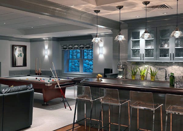 Stylish basement with a pool table, bar counter, transparent bar stools, and a framed jersey on the wall