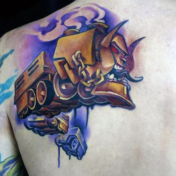 Futuristic tattoo of a robotic creature fused with a tank, using bold purple and gold tones across the shoulder and upper back.