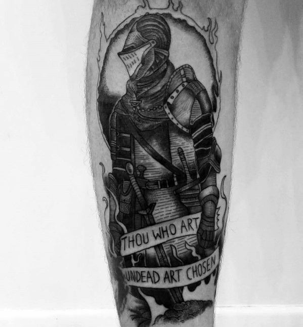 Blackwork Dark Souls tattoo of the Chosen Undead in detailed armor, framed by flames with a banner reading “Thou who art undead art chosen.”