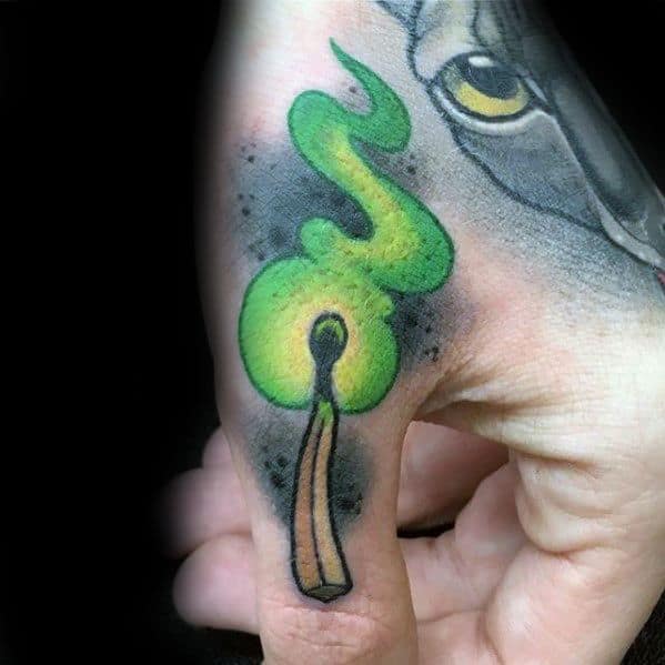 Tattoo of a lit matchstick with green flame on a finger.