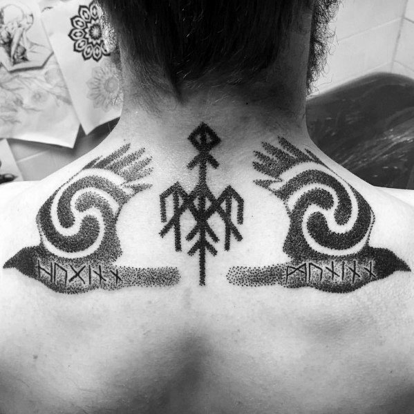 Dotwork tattoo of Huginn and Muninn with runes and a Vegvisir-like Norse symbol, inked symmetrically across the upper back.