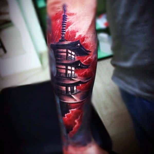 Forearm tattoo of a Japanese pagoda with a glowing moon and intense red lightning-filled sky for a bold, dramatic effect.