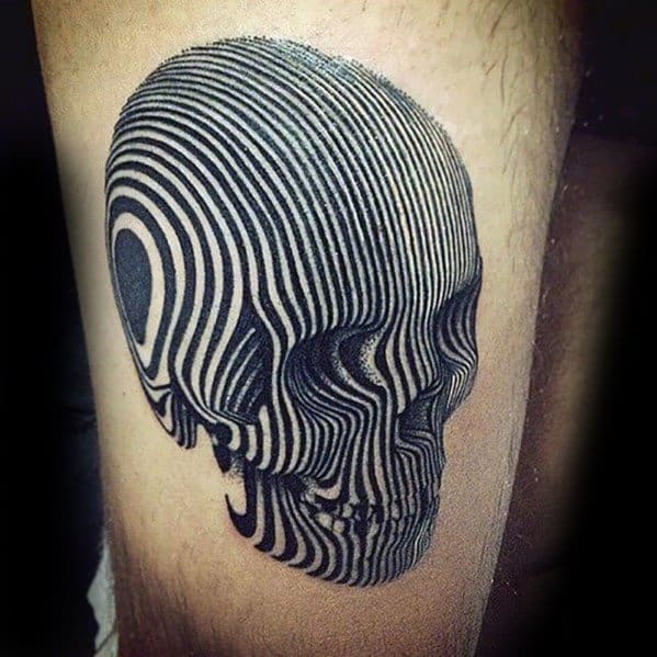 Optical illusion tattoo of a skull formed entirely by warped black and white lines, creating a 3D effect on the skin.