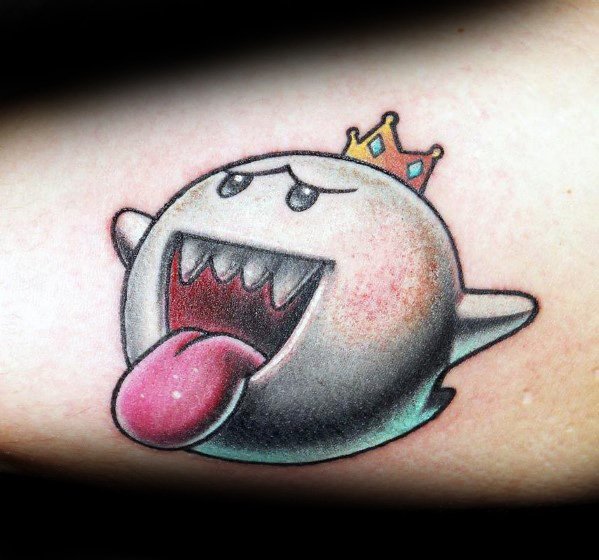 Mario ghost tattoo featuring King Boo with a golden crown, wide grin, and tongue out, inked with smooth shading and vibrant colors.
