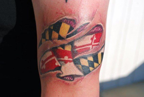 Maryland flag tattoo with a torn skin effect on the arm, creating a 3D illusion of the flag beneath the surface for a bold look.