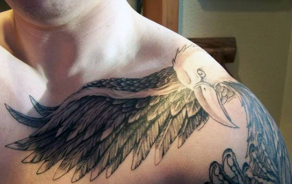 Detailed bird tattoo with wings spread across shoulder and chest