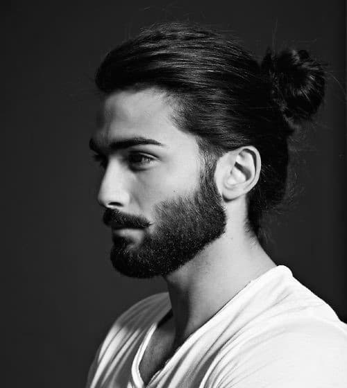 Man with long hair in a bun and a full beard
