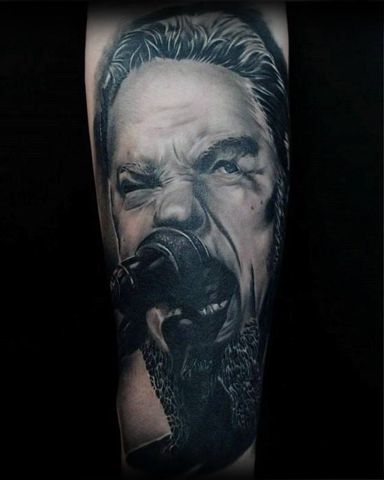 Realistic black and grey portrait tattoo of James Hetfield passionately singing into a microphone, capturing intense stage emotion.