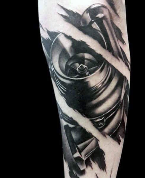 Black and grey tattoo of a wristwatch mechanism with torn, ripped skin effect around it