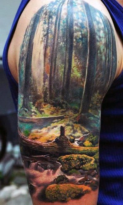 Tattoo of a forest scene with tall trees, a stream, rocks, and moss on an upper arm