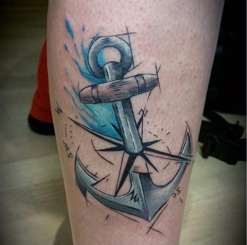 Tattoo of a grey anchor adorned with blue watercolor splash and intricate compass markings artfully covering the back of a leg