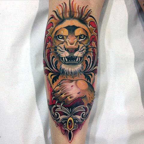 Neo-traditional lion tattoo with stylized flames, bold patterns, and regal posture, blending vibrant red, gold, and black tones.