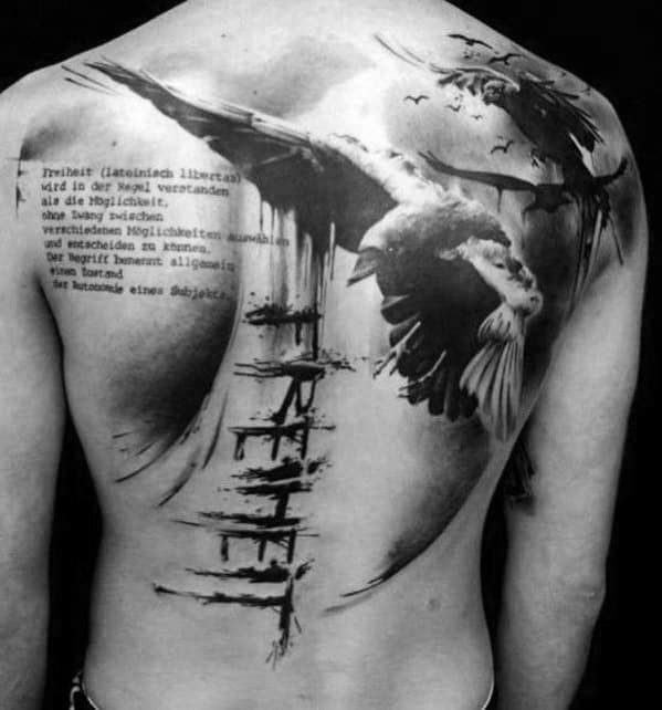 Expressive back tattoo with flying ravens, abstract brushstroke effects, and the German word “Freiheit” (freedom), symbolizing liberation and power.