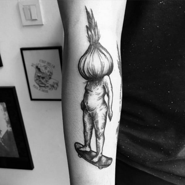 Surreal black and grey tattoo of a humanoid figure with an onion head riding a skateboard, featuring fine line details and artistic shading.