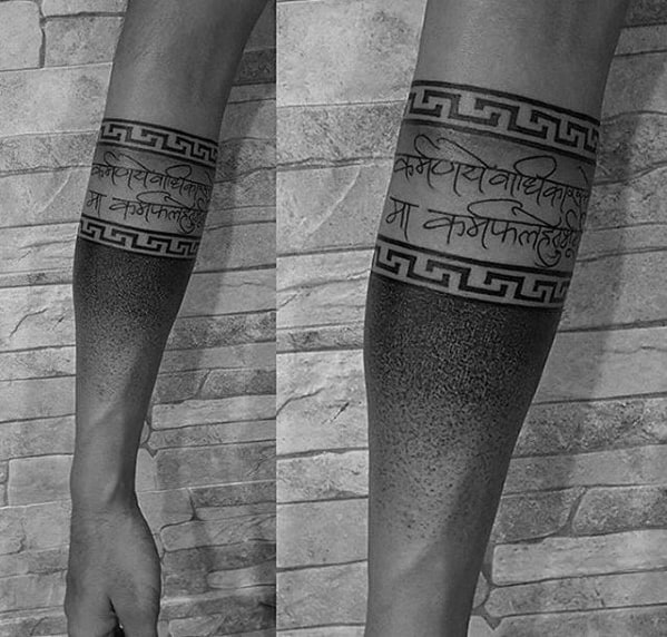 Forearm tattoo with Sanskrit text, geometric band, and gradient dotwork design