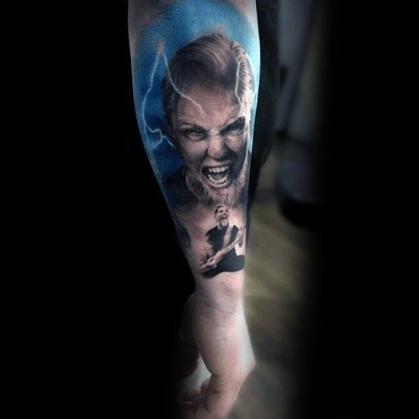 Vivid forearm tattoo of James Hetfield screaming with lightning and blue tones, featuring a smaller image of him playing guitar below.