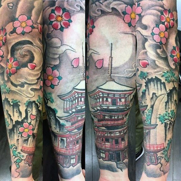 Colorful full sleeve tattoo of a Japanese pagoda with pink cherry blossoms, swirling clouds, mountains, and a glowing full moon.