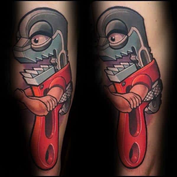 Colorful cartoon-style tattoo of a humanoid pipe wrench character with muscular arms, wearing a red handle and fierce expression.