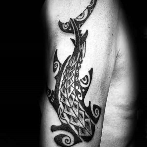 Polynesian shark tattoo on upper arm with bold geometric patterns and swirling elements symbolizing protection, strength, and ocean spirit.
