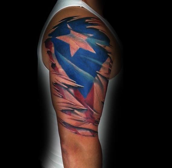 Puerto Rican flag tattoo with a ripped skin effect on the upper arm, revealing bold red, white, and blue colors with a striking star design.