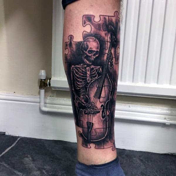 Mens Puzzle Tattoos Of Skeleton Playing Musical Instrument On Legs