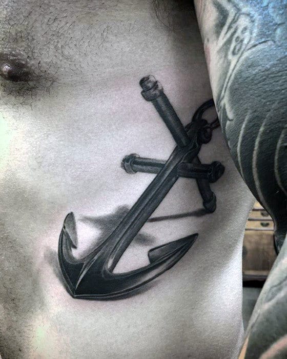 A striking tattoo of a large black anchor adorns the ribcage