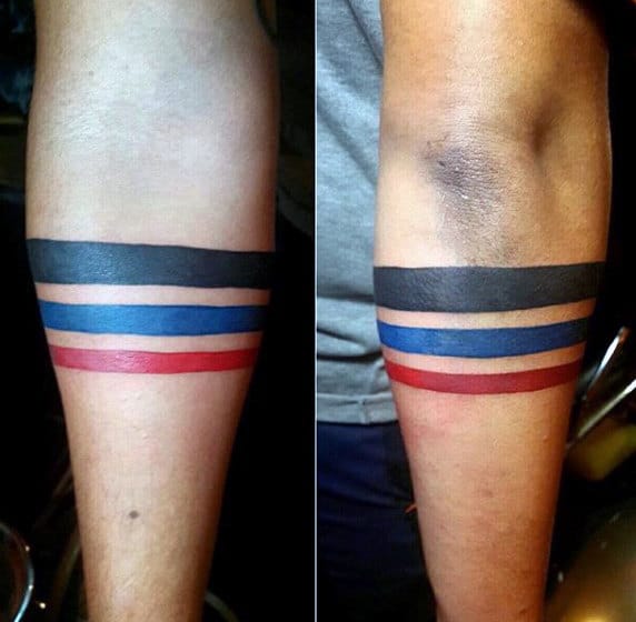 Two forearms with tattoos of parallel black, blue, and red bands