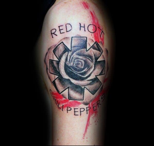 Upper arm tattoo with the Red Hot Chili Peppers logo, a black and grey rose in the center, band name text, and red brushstroke accents.