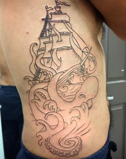 Tattoo of a sailing ship and octopus on a person's ribcage