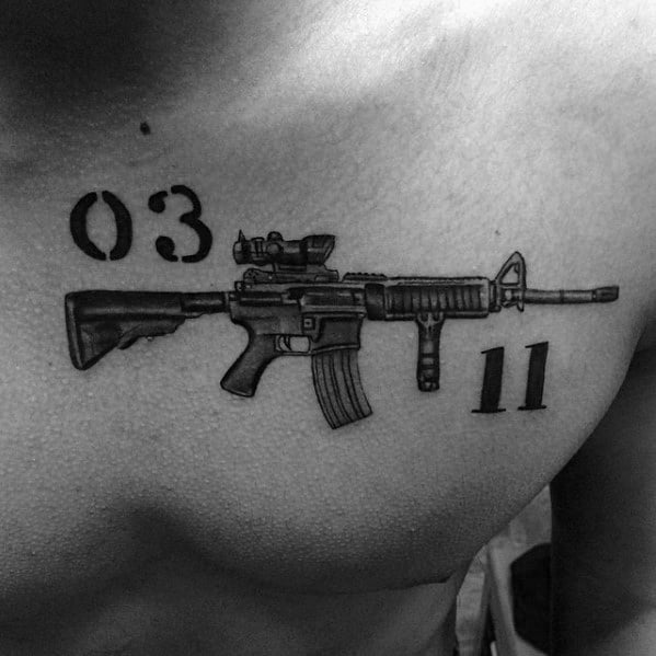 Black and grey chest tattoo featuring an AR-15 with "03" and "11" text, symbolizing military service, brotherhood, and strength.