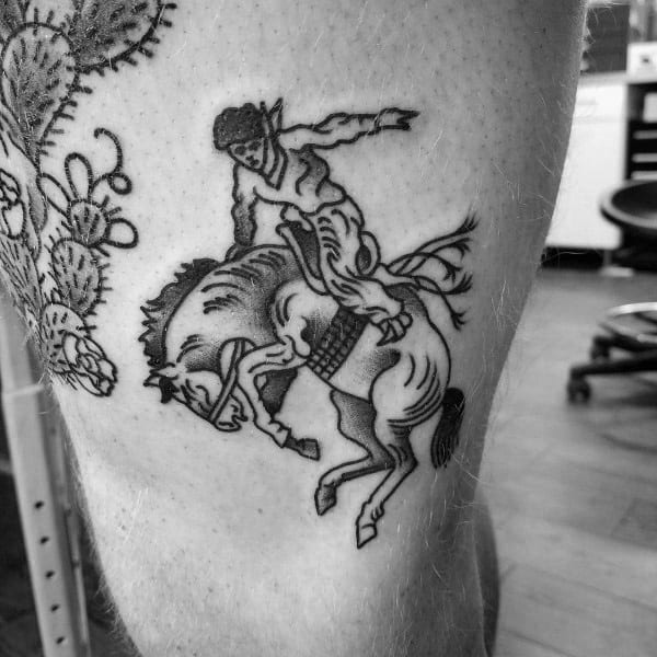 Black and grey traditional-style tattoo of a cowboy riding a bucking horse, featuring bold outlines, minimal shading, and a classic Western feel.