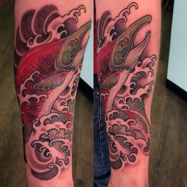 Vibrant tattoo of a red salmon leaping through stylized waves, featuring bold colors and dynamic motion for a striking forearm sleeve design.
