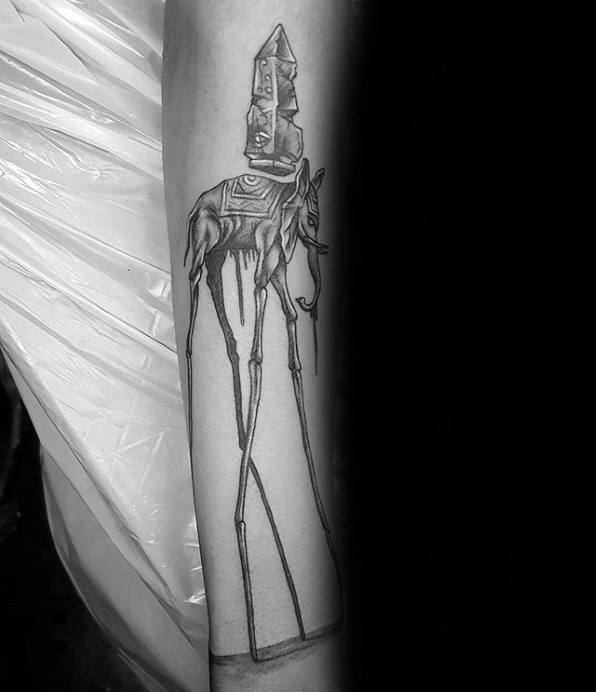 Black and grey tattoo of a Salvador Dali-style elephant with elongated legs and an obelisk on its back, dripping with surreal details.