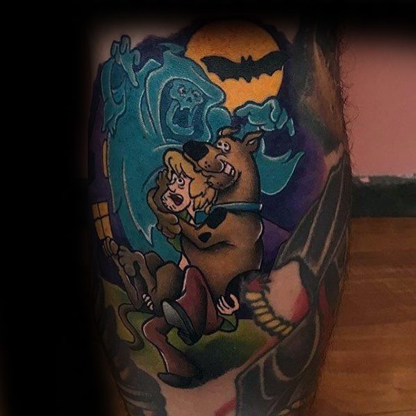 Tattoo of Shaggy and Scooby-Doo hugging in fear with a glowing ghost behind them, set against a dark night with a full moon and bat.