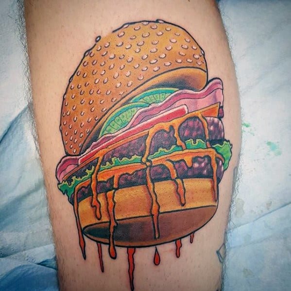 Vibrant tattoo of a juicy cheeseburger with lettuce, tomato, and dripping sauce on a person's skin